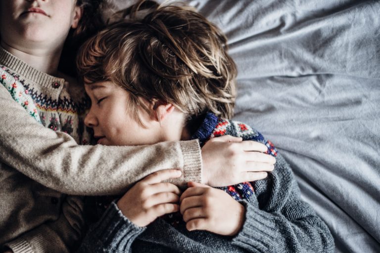 Niño durmiendo junto a su hermana