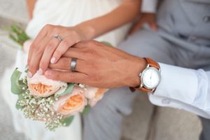 Manos de esposa encima de mano de esposo en su boda
