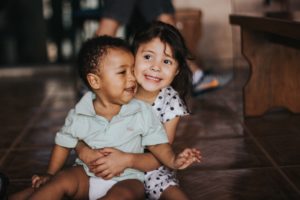 Niña junto a su hermanito riendo