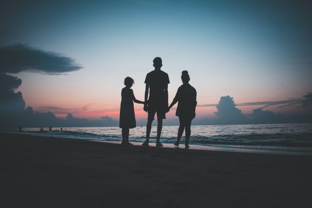 Familia viendo un atardecer en la playa