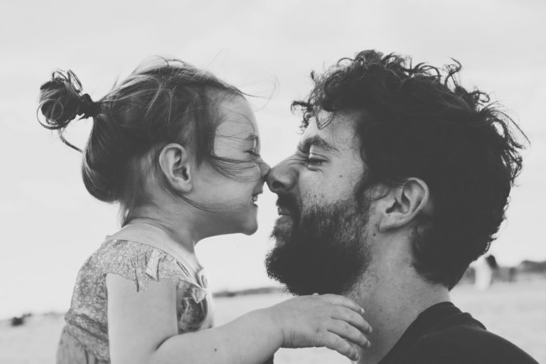 Hombre con su hija riendo y tocando su nariz