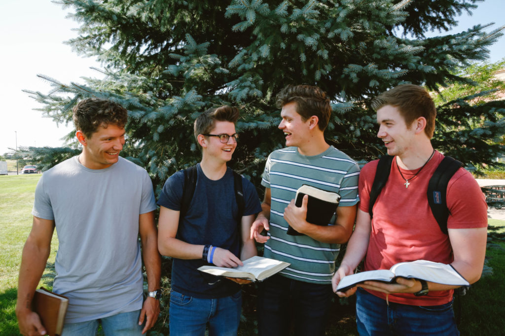 hombres jovenes leyendo la biblia en la escuela