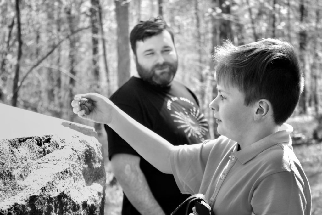 Padre junto a su hijo en un bosque compartiendo