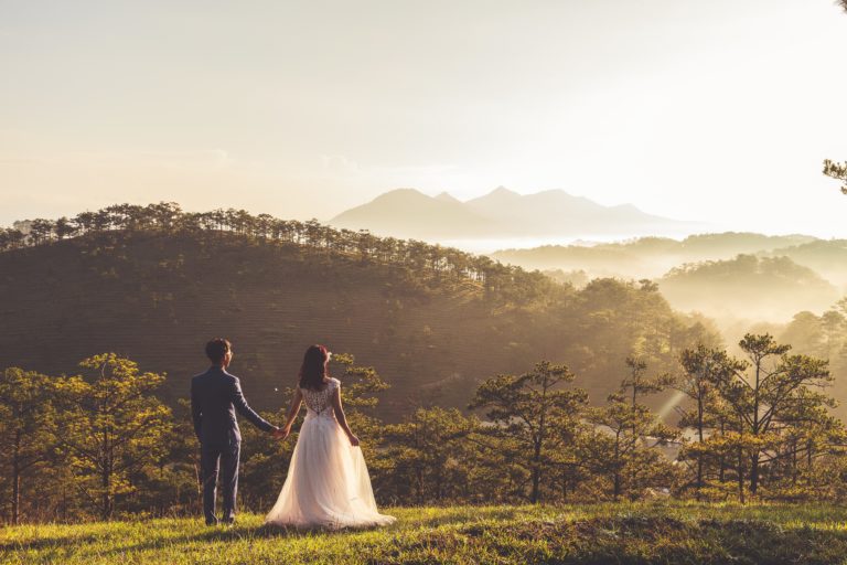 Recien casados en un monte viendo las montañas