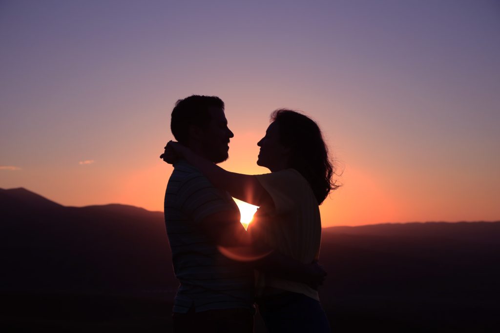 Un matrimonio abrazados en el atardecer