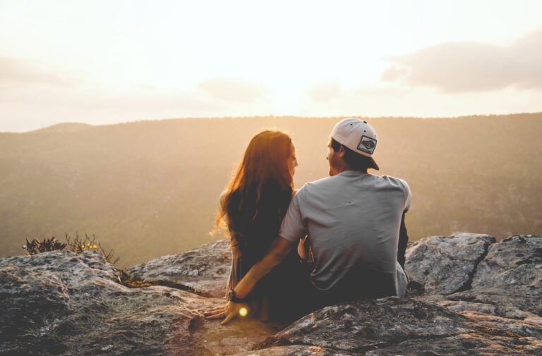 Una matrimonio mirando el atardecer en una montaña